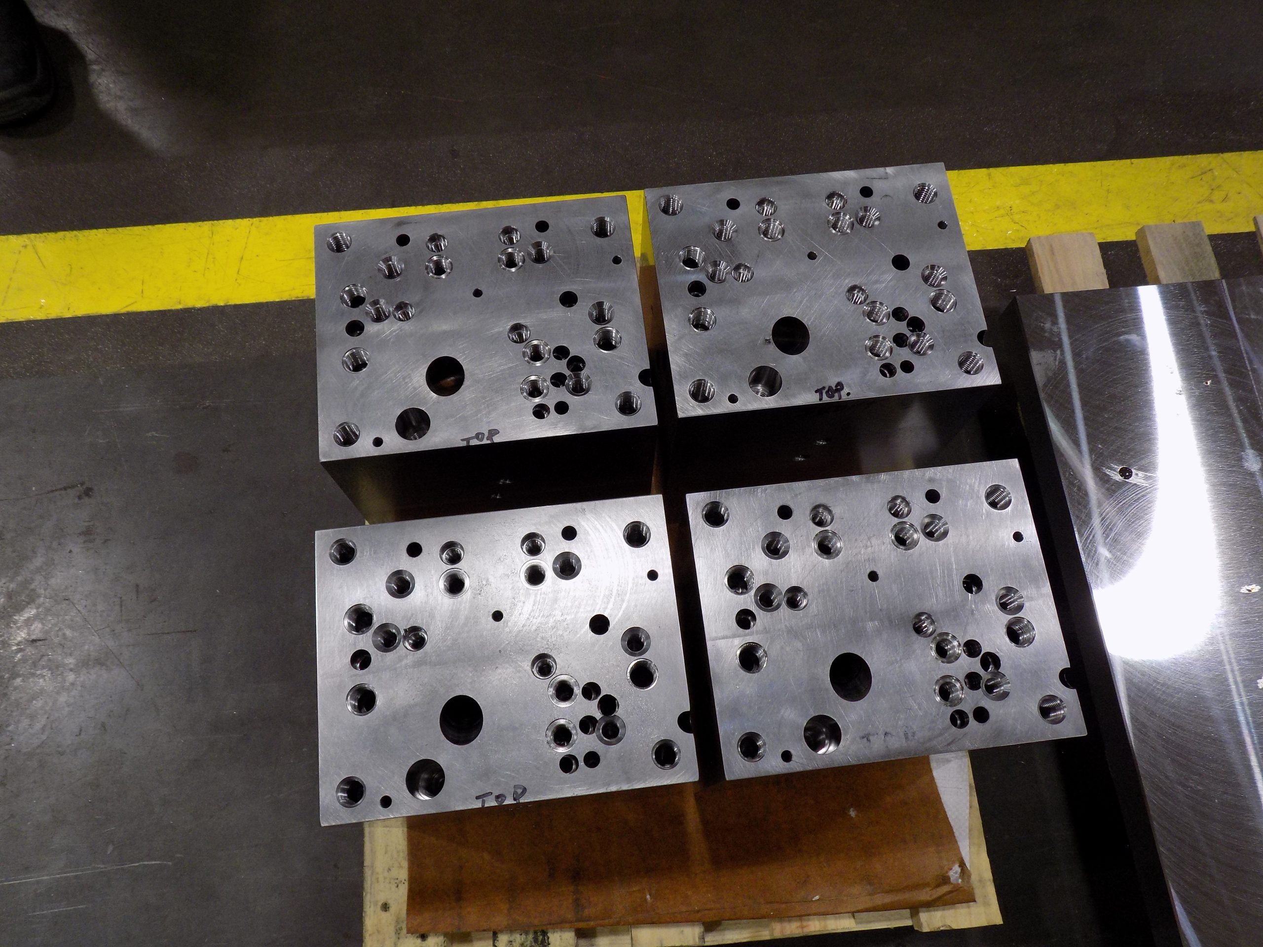 Four steel blocks used for gun drilling.